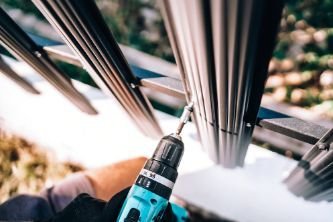 A close up shot of a professional fencer from Titan Fencing Melville's team repairing a broken metal fence panel in WA.
