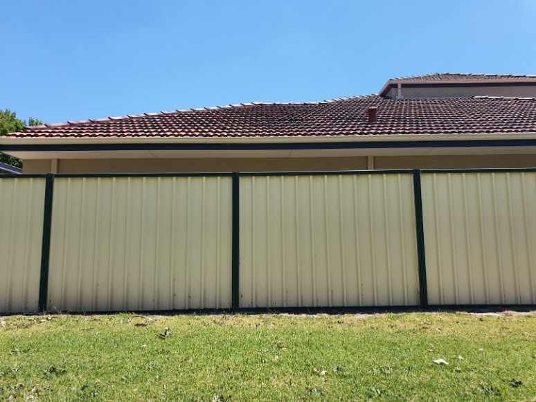 Multi-coloured customised Colorbond fencing installed in a residential backyard in Melville WA.